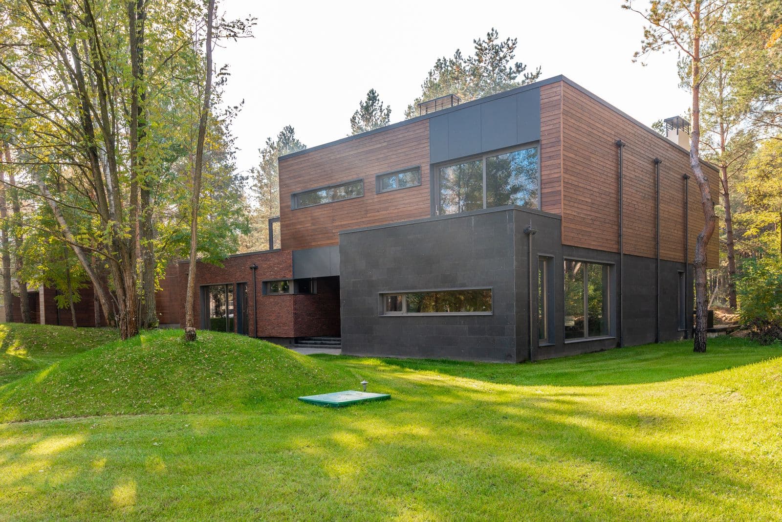 Maison contemporaine associant bardage bois à lames horizontales et façade enduite gris foncé